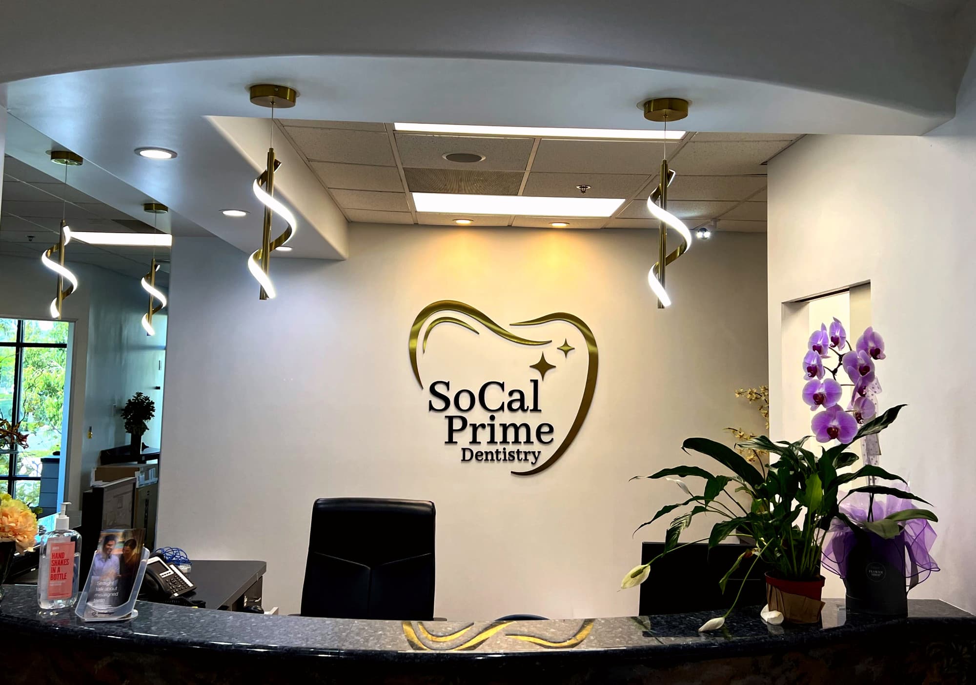 SoCal Prime Dentistry reception area featuring modern decor, logo, and orchids, located in Rancho Santa Margarita, CA.
