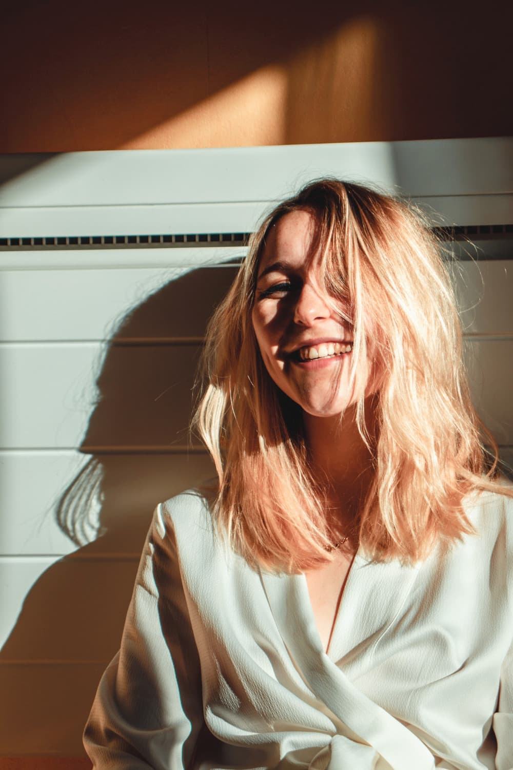 Smiling woman with blonde hair in a bright, calm environment, reflecting comfort and trust, relevant to personalized dental care at SoCal Prime Dentistry.